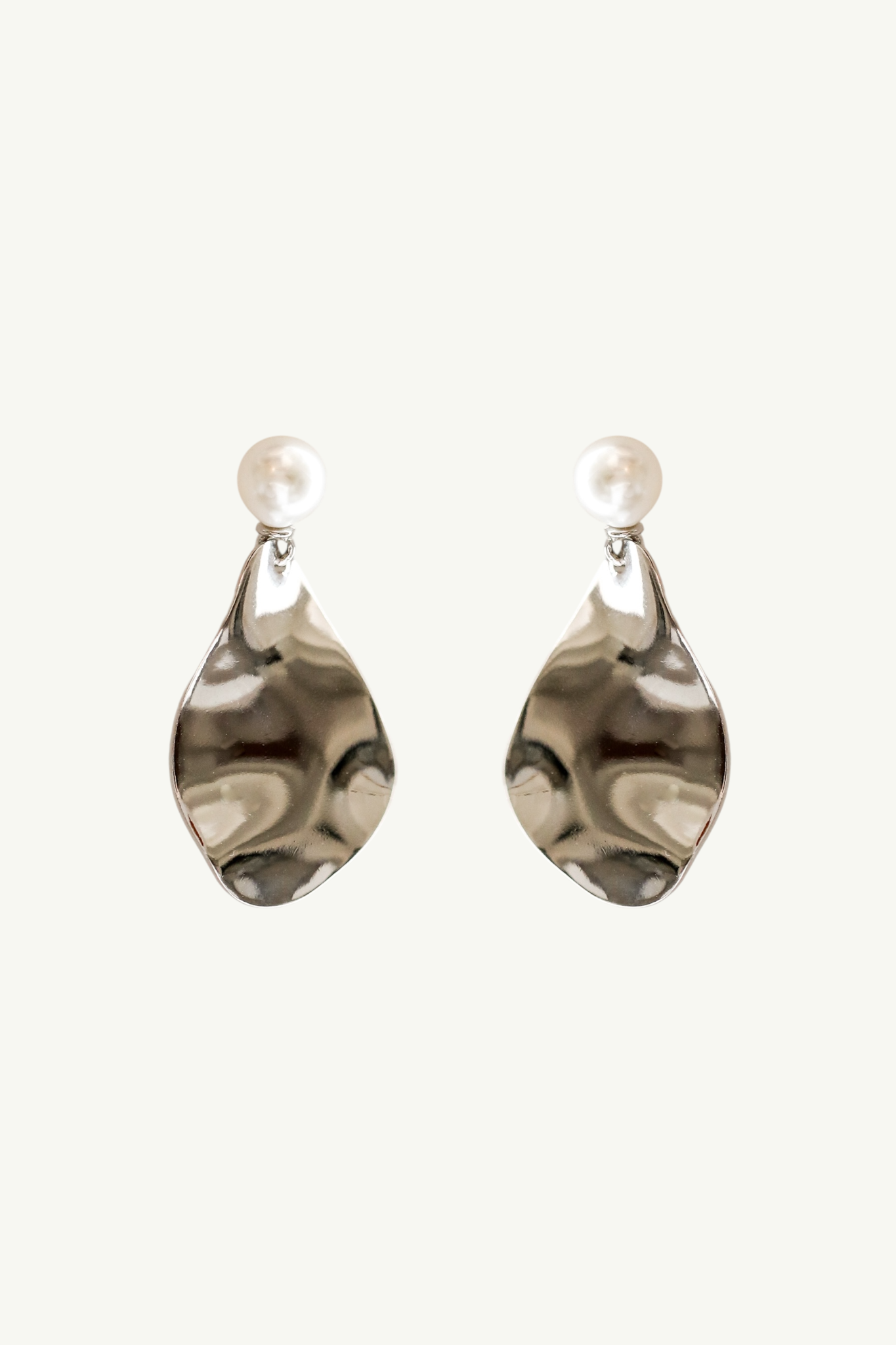 Flat image on white background of a pair of sculptural gold metallic earrings with a pearl stud accent