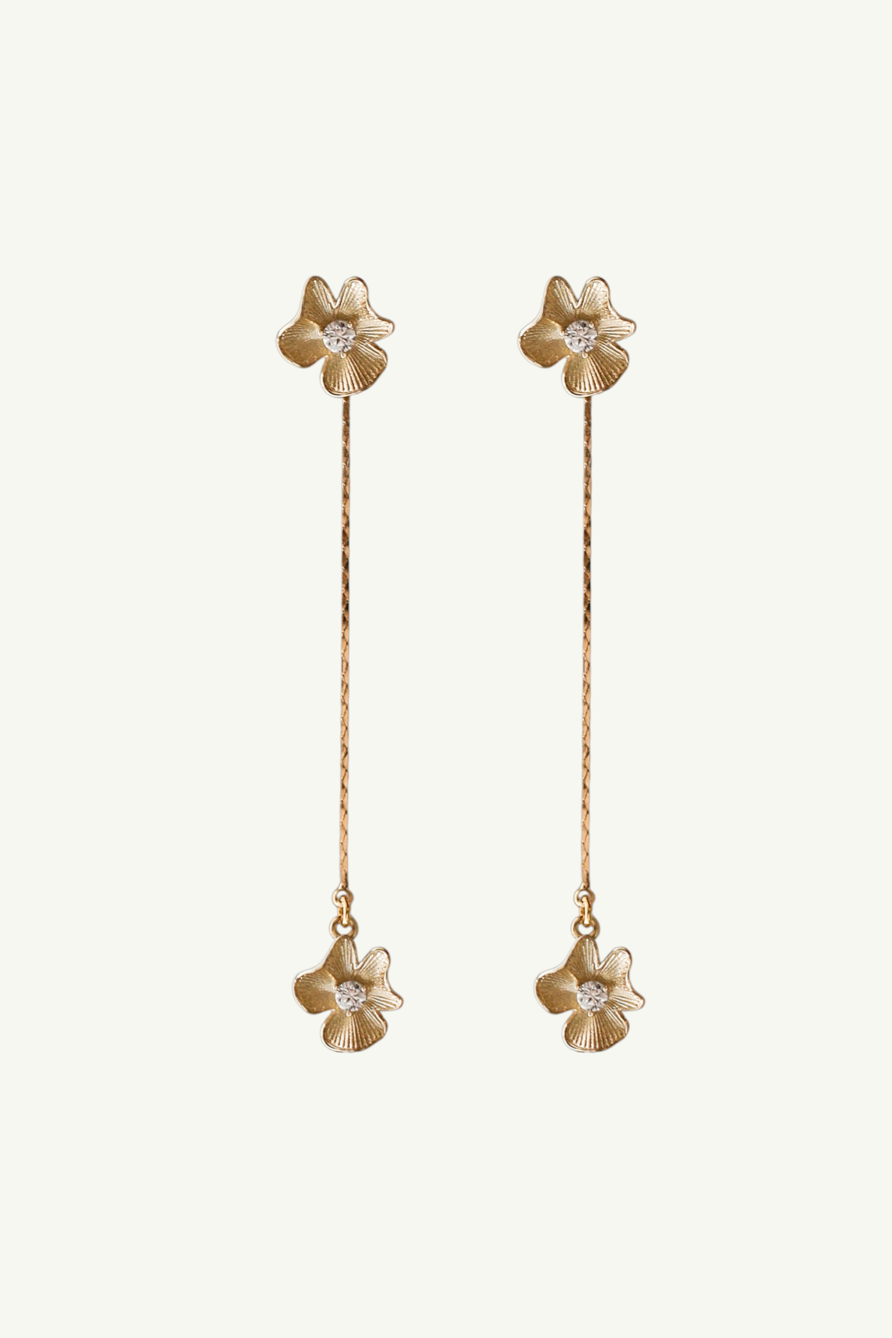Flat image on white background of gold plated mini flower earrings with crystal accents on a petite gold strand drop