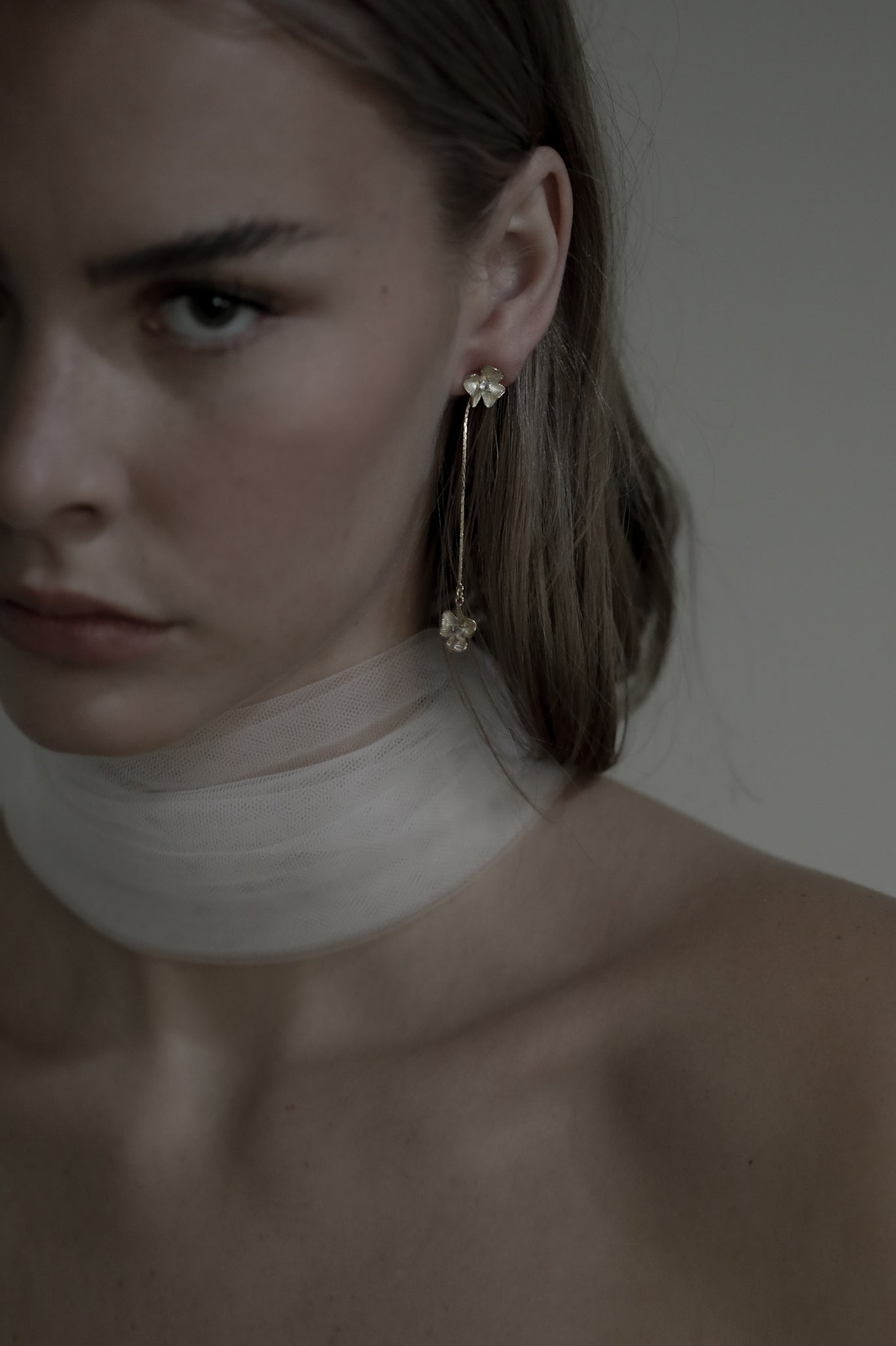 Gold plated floral strand earring with rhinestone accents worn by brunette bride wearing a silk bridal scarf