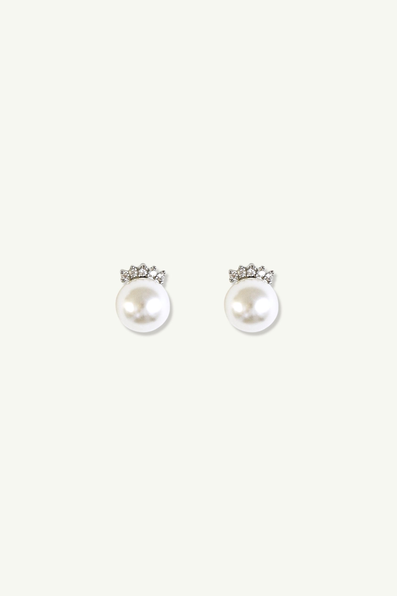 Pair of pave pearl earrings by Studio Bride silver pave crystal accents on a white background