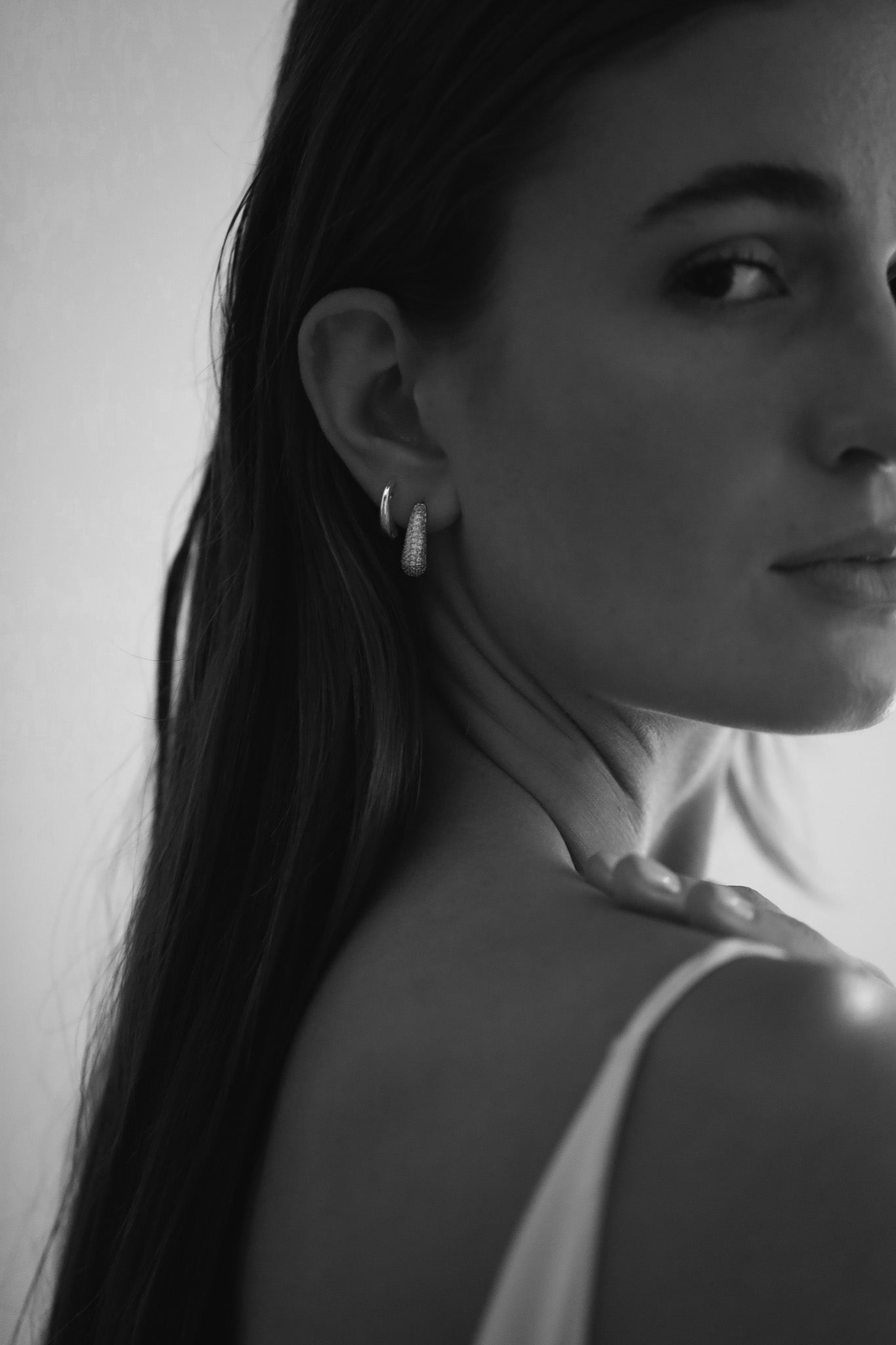 Black and white photo of bride wearing the silver pave orb earring set by Studio Bride
