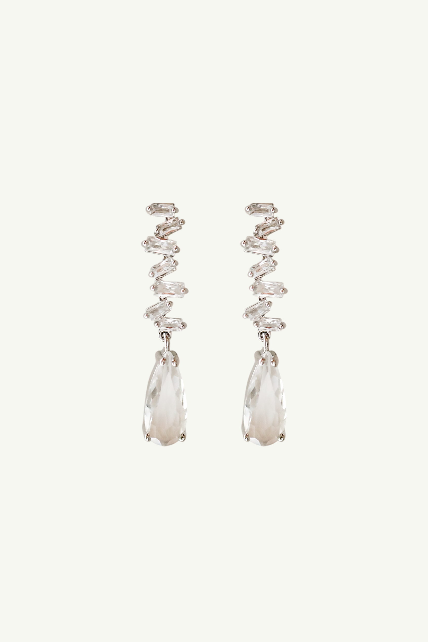 Flat photo of stacked baguette rhinestone earrings featuring a larger crystal drop by Studio Bride on white background
