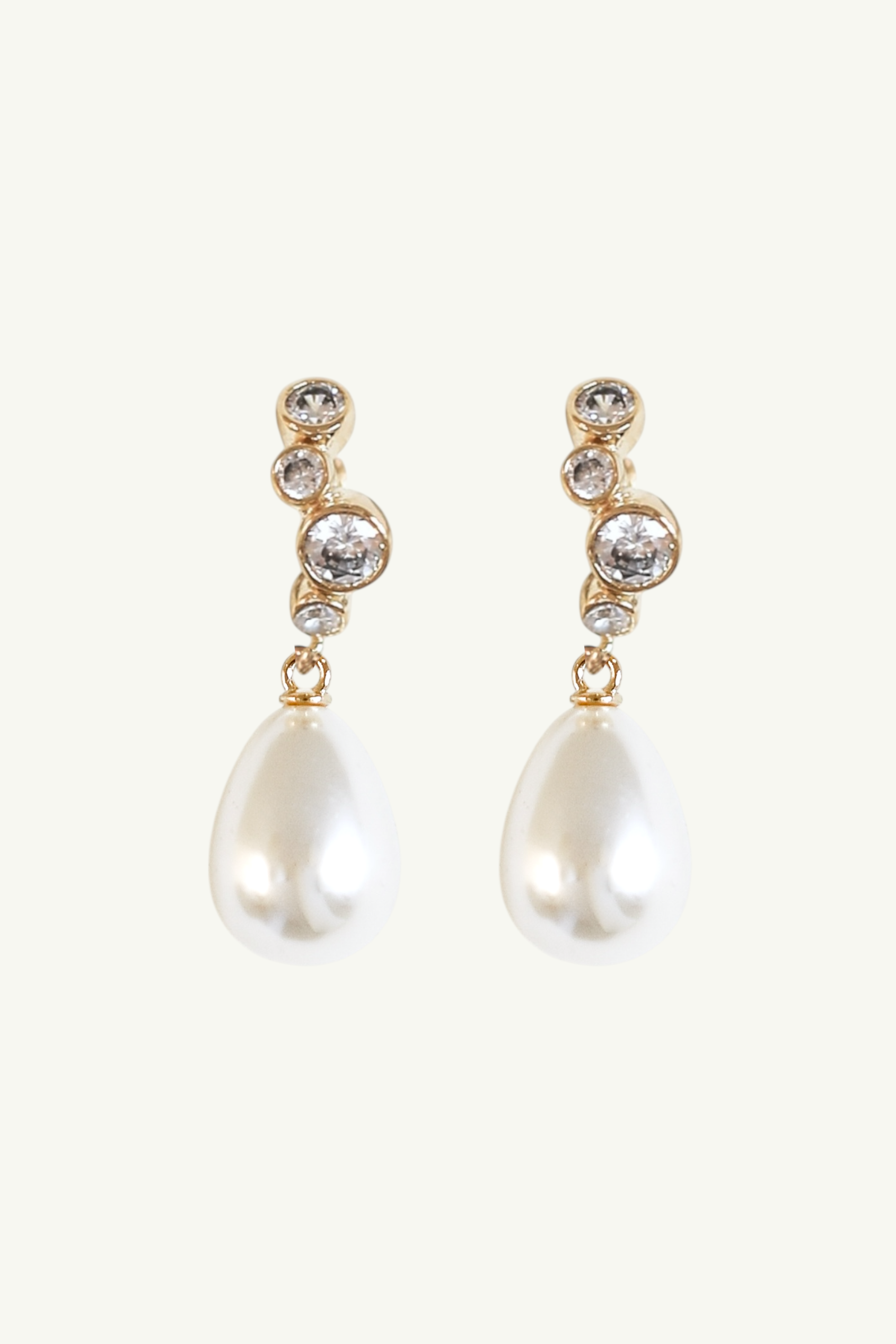 Flat photo of the stacked bezel pearl hoop drop earrings in gold by Studio Bride on white background