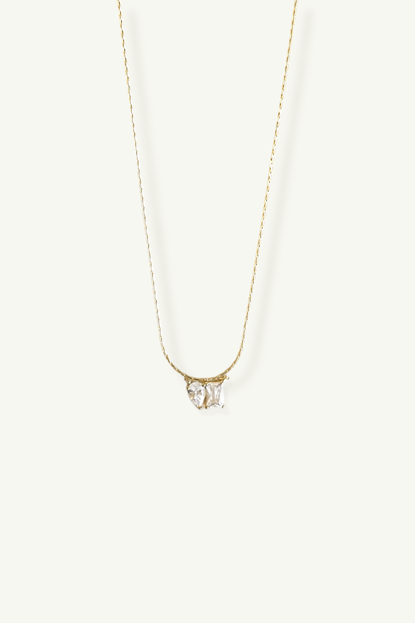 Gold necklace with a CZ pendant by Studio Bride Jewelry on a white background
