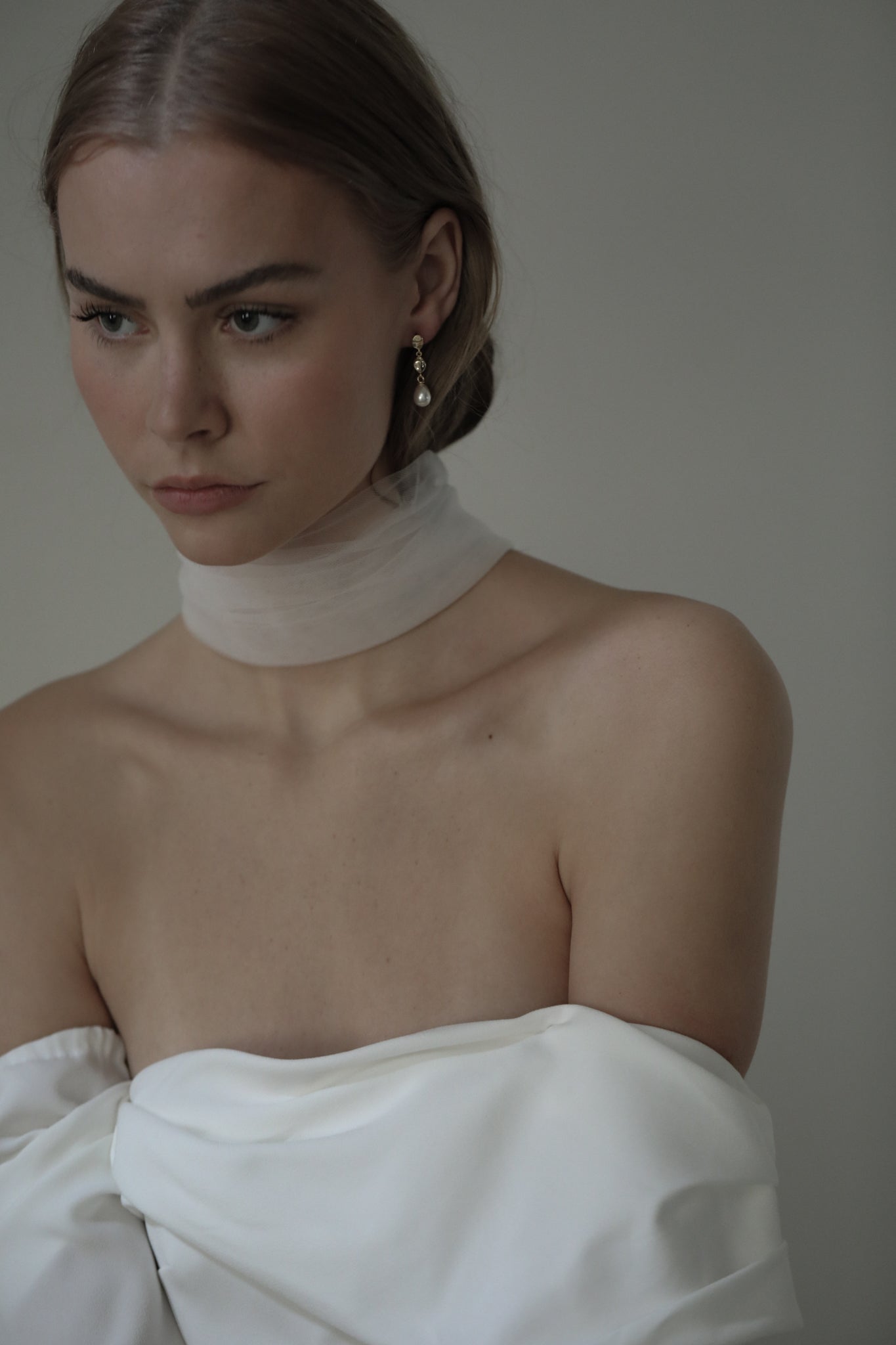 Bride wearing an off the shoulder wedding gown paired with silk necktie and the gold gilded bridal pearl drop earrings