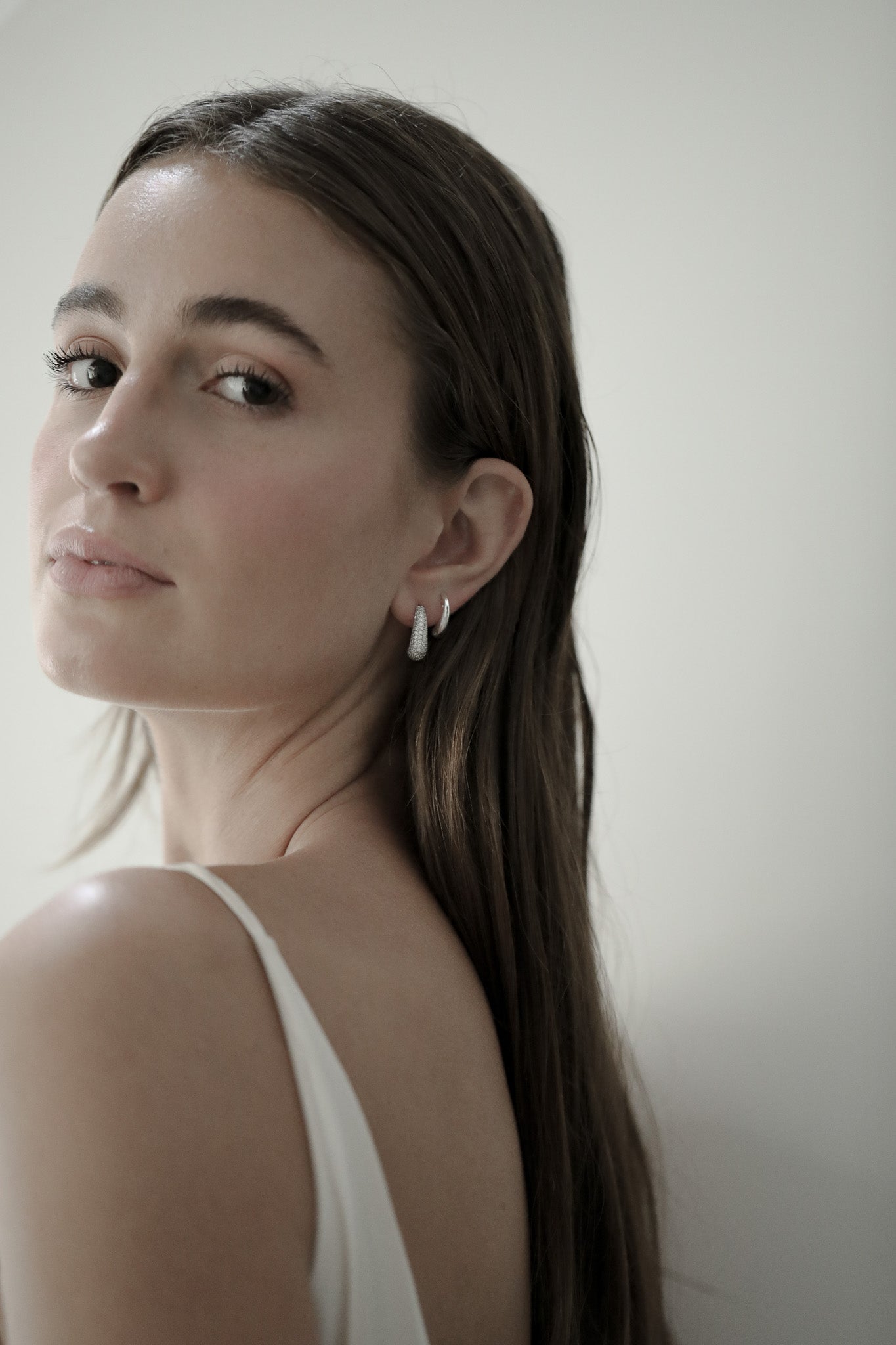 Brunette bride wearing the silver pave orb earrings by Studio Bride